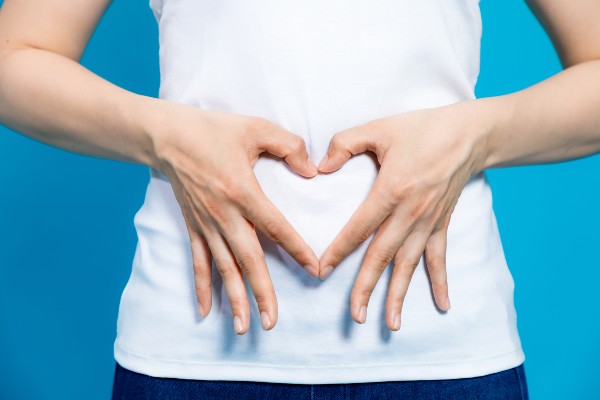 Flora batterica intestinale: donna forma un cuore con le mani sull'addome
