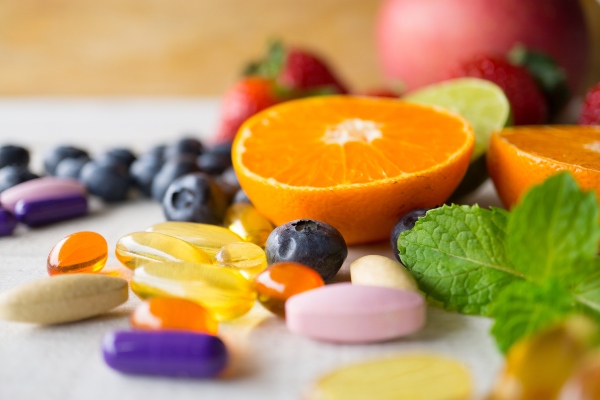 Concept per il controllo del peso: frutta varia e integratori alimentari colorati