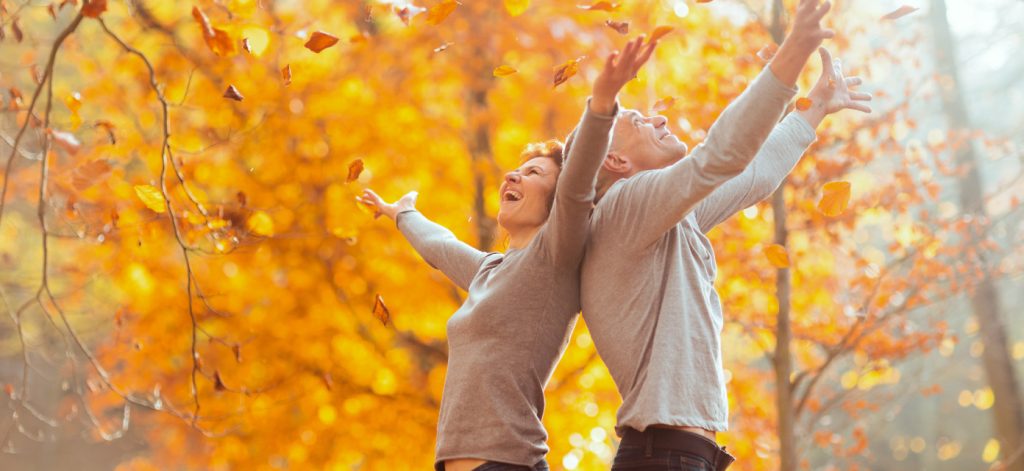 Concept per aumentare le difese immunitarie: persone felici in un bosco autunnale - Più Medical