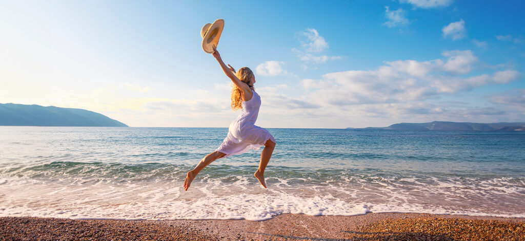 Concept per integratori di magnesio: donna salta su una spiaggia - Più Medical