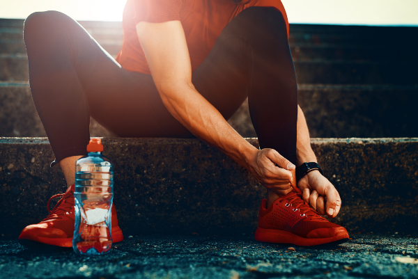 Concept per integratori di magnesio: close up su uno sportivo che si allaccia le scarpe da corsa - Più Medical