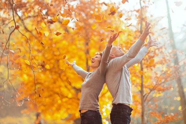 Concept per zinco e difese immunitarie: due persone sorridenti in mezzo ad un bosco autunnale - Più Medical