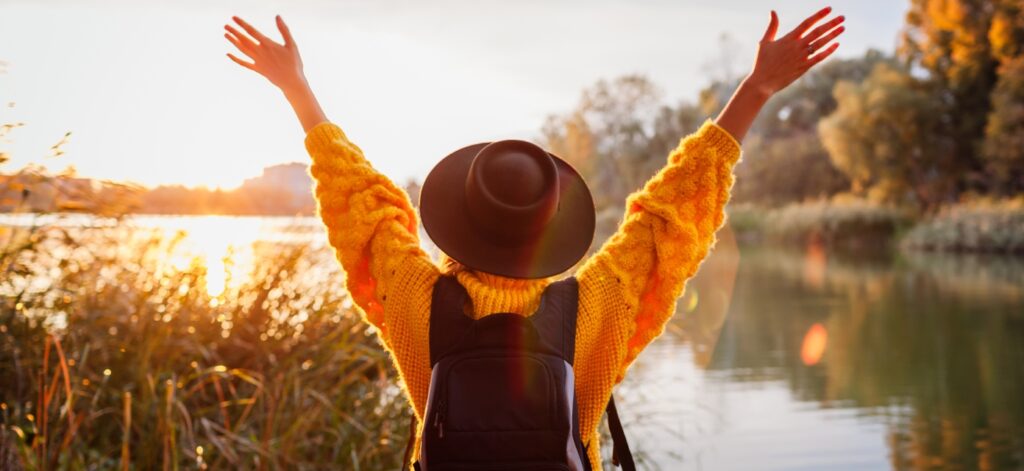 Concept per zinco e difese immunitarie: persona in autunno guarda verso un lago con le braccia alzate - Più Medical