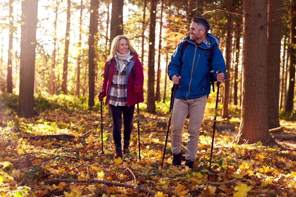 Concept per dolore alle articolazioni: coppia over 50 che fa trekking in un bosco - Più Medical