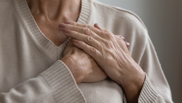 Close up di mani di una donna anziana premute sul petto - conept per elettrocardiogramma in farmacia 