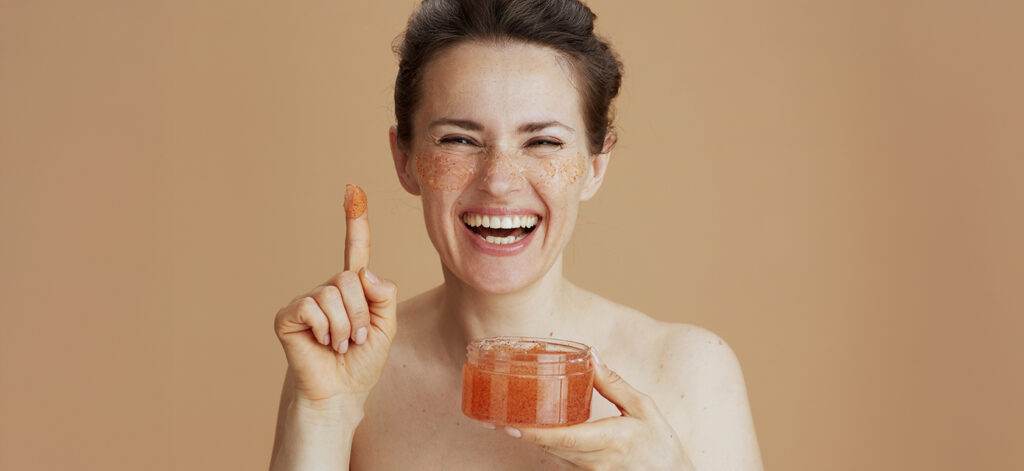 Cura della pelle del viso: donna sorridente con un barattolo di crema in mano