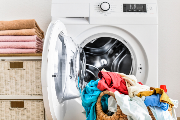 Concept per sindrome da rientro: lavatrice con all'interno abiti estivi