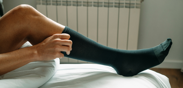 Concept per insufficienza venosa: uomo indossa calze a compressione graduata