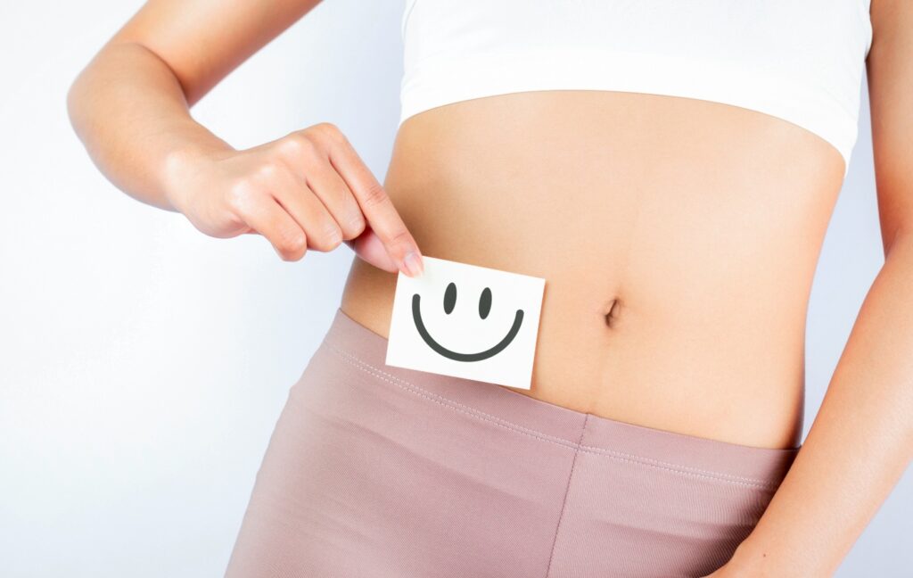 Concept per intestino sano: primo piano di addome femminile con emoji sorridente