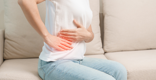 Concept per depurare il fegato: close up su donna che tiene le mani sul fianco dolorante