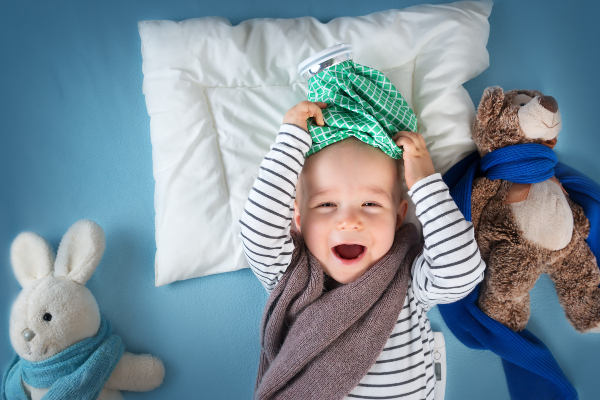 Concept per mal di testa bambini: bambino di qualche mese a letto, con borsa del ghiaccio sulla testa