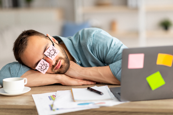 Concept per rimedi per dormire: uomo addormentato alla scrivania